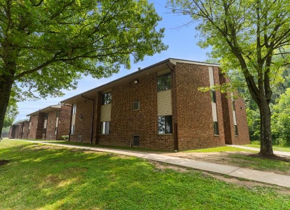 a row of brick buildings with trees in front of them  at Belvedere Acres Apartments, Washington, PA