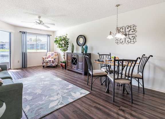A living room with a dining table and chairs Fishermans Landing Apartments in Ormond Beach, FL.