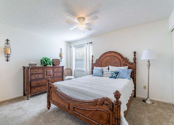 A bedroom with a large bed and a dresser Fishermans Landing Apartments in Ormond Beach, FL.