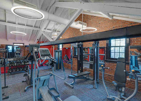a gym with weights and cardio equipment and a brick wall at Ninth Square Apartments, Connecticut, 06510
