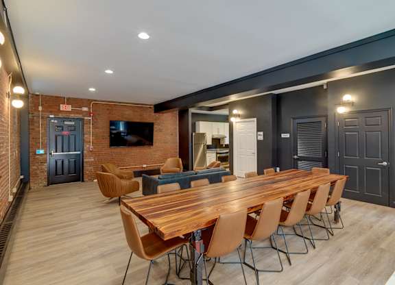 Community room with a long wooden table and chairs and tv at Ninth Square Apartments, Connecticut