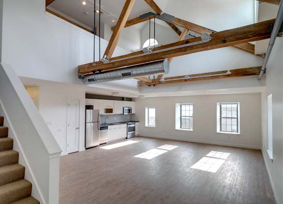 Living room and kitchen with wood flooring at Ames Shovel Works Apartments, North Easton, MA, Massachusetts