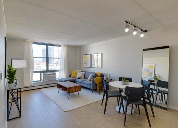 an open living room and dining room with a table and chairs and a large window at Ninth Square Apartments, Connecticut