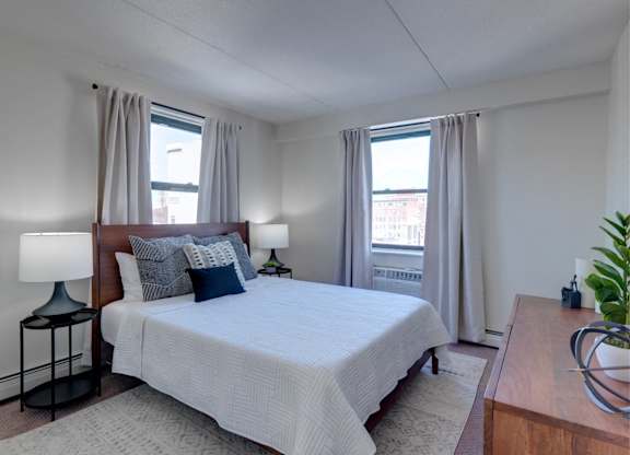 a bedroom with a large bed and two windows at Ninth Square Apartments, Connecticut, 06510