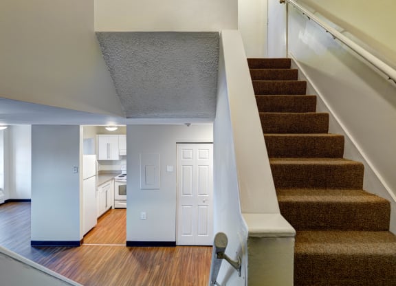 a view of a staircase in a home with a kitchen in the distance at Chapman House, E. Boston
