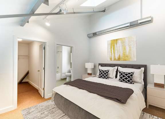 a bedroom with a large bed and a closetat Ames Shovel Works Apartments, North Easton, Massachusetts