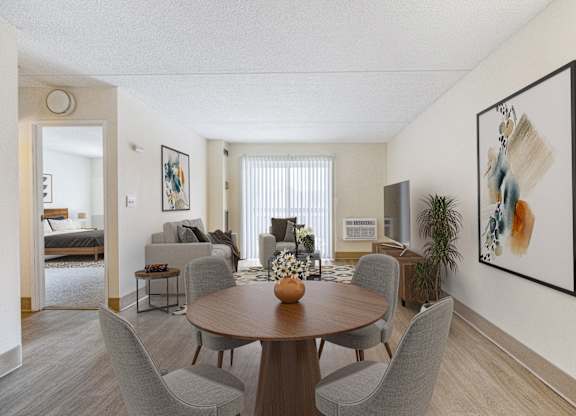 A living room of an apartment with a table and chairs at North Stoughton Village Apartments in Stoughton, MA