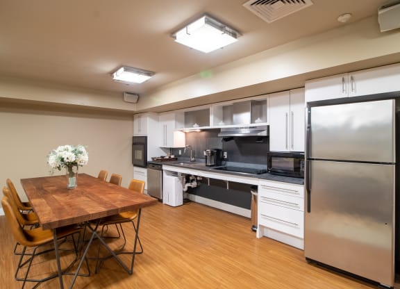 Community Room Area With Kitchen And Tables Wilber School Apartments.