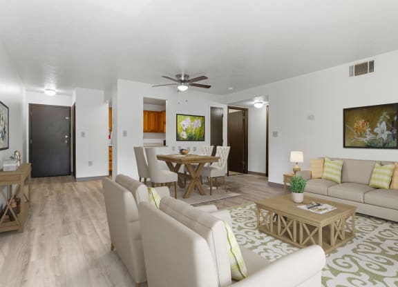 a living room with couches a table and chairs and a ceiling fan at Huntingdon Village Apartments, Hunker, Pennsylvania