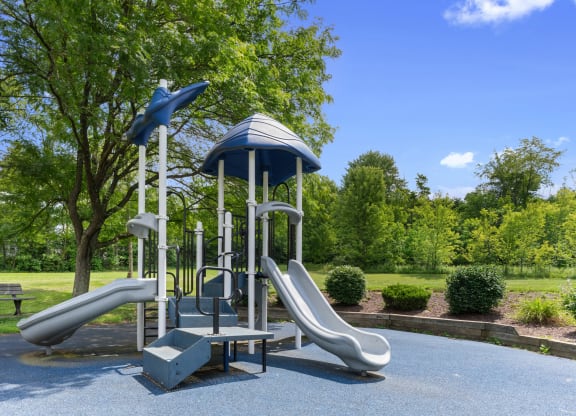 A playground with slides in a park at Huntingdon Village Hunker, PA. at Huntingdon Village Apartments, Hunker, 15639