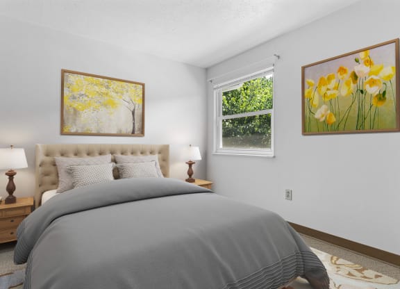 a bedroom with grey bedding and two paintings on the wall at Huntingdon Village Apartments, Pennsylvania, 15639