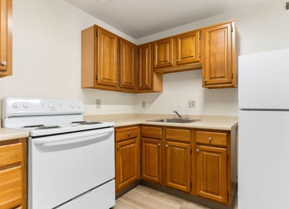 A kitchen with white appliances and wooden cabinets at Huntingdon Village Hunker, PA.