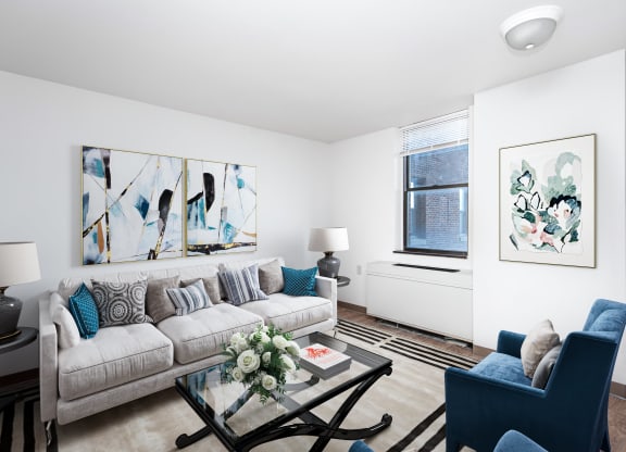 a living room with white walls and a large window at Richford Arms Apartments, Erie
