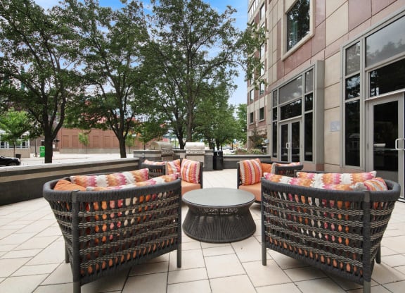 a patio with chairs and a table in front of a building