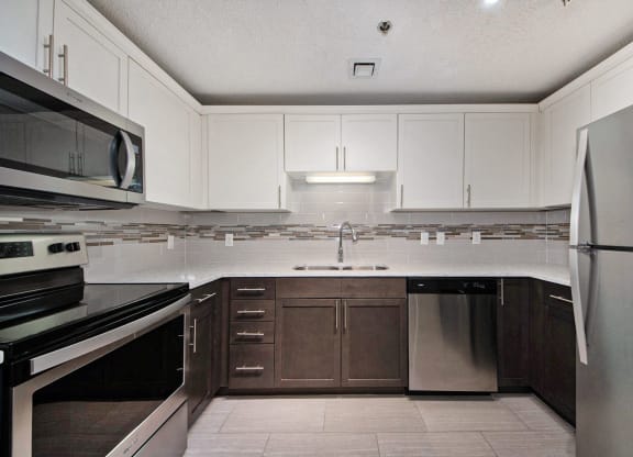 a kitchen with white cabinets and stainless steel appliances