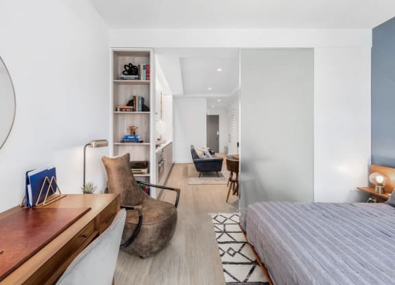 a bedroom with a bed and a desk and a living room
