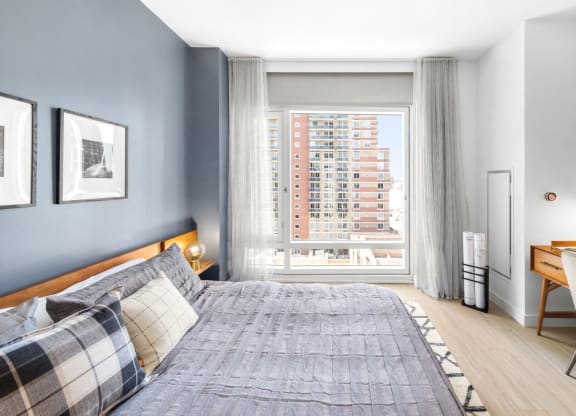 a bedroom with a bed and a large window