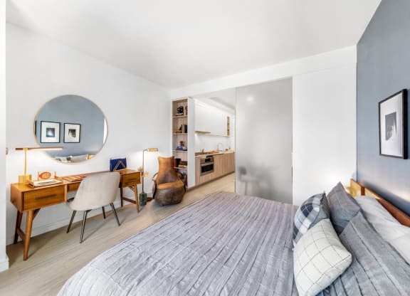 a bedroom with a bed and a desk and a mirror