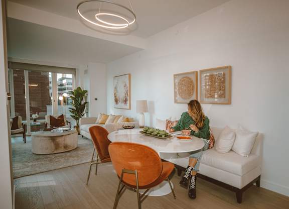 A woman is sitting at a table in a modern dining room.