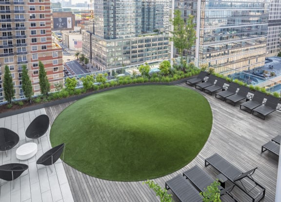 a green roof terrace with a lawn and city buildings