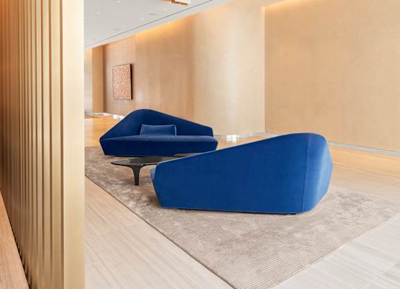 A modern living room with a blue chair and a wooden floor.