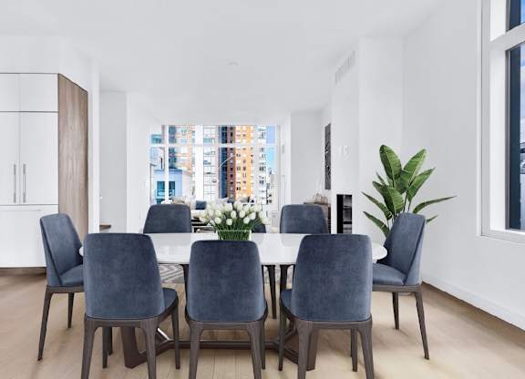 A dining room with a table and chairs.