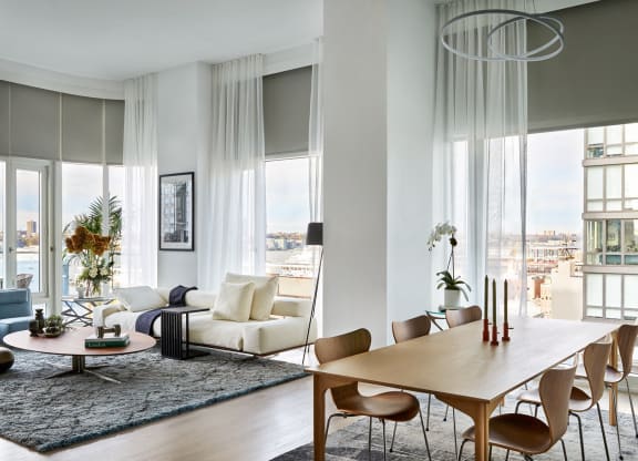 a living room with a dining room table and a large window