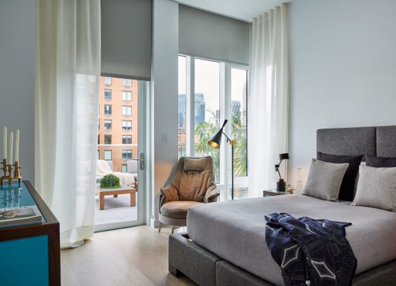 a bedroom with a bed and a chair and sliding glass doors