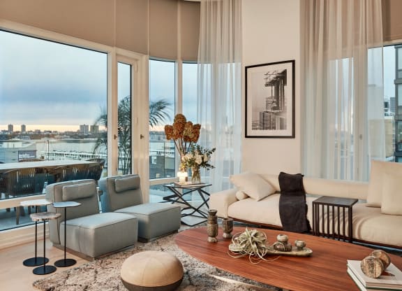 a living room with a view of the city and a couch and chairs