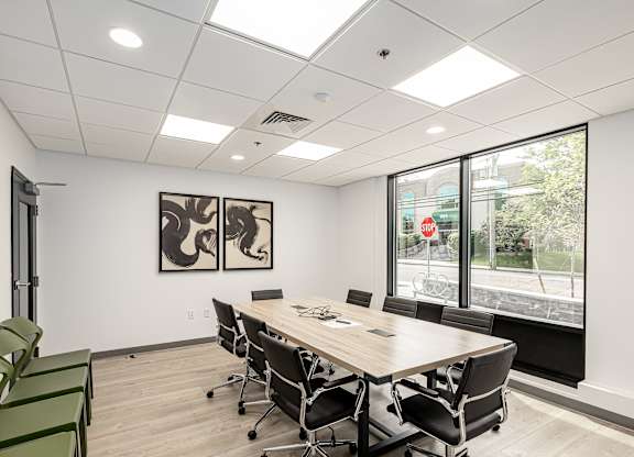 A conference room with a long table and chairs.