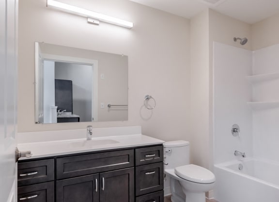 a bathroom with a toilet sink and mirror and a shower
