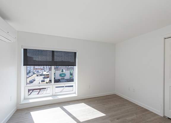 A room with a window overlooking a street.