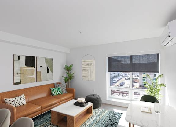 A living room with a brown couch, a white chair, and a coffee table.