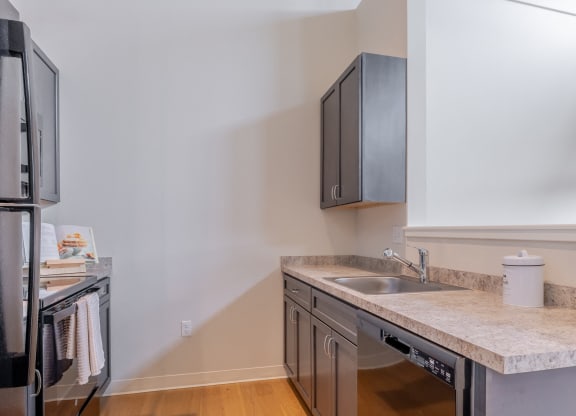 an empty kitchen with a sink and a refrigerator and a microwave