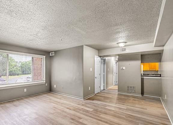 A room with a window and wooden floors.