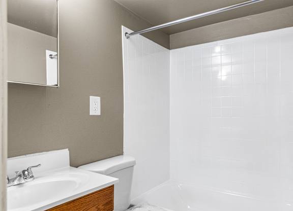 A white bathroom with a white tub and sink.