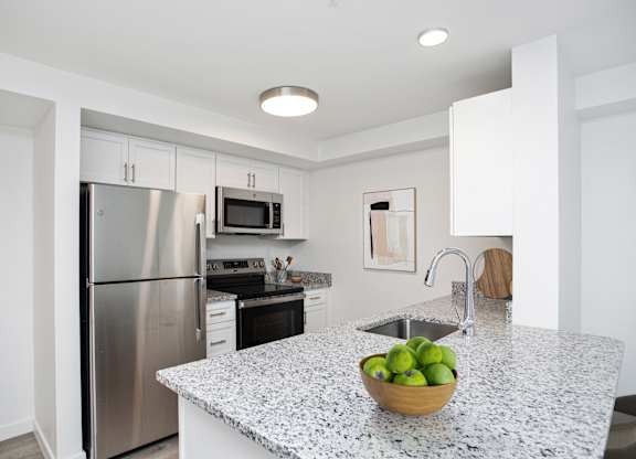 A kitchen with granite countertops and stainless steel appliances.