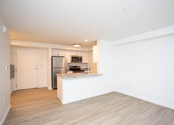 A kitchen with a refrigerator, microwave, and sink.at The Camelot, West Hartford, CT  