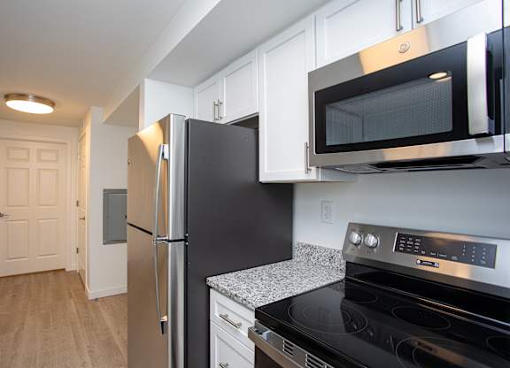 A kitchen with black appliances and white cabinets.at The Camelot, West Hartford, CT 06119  