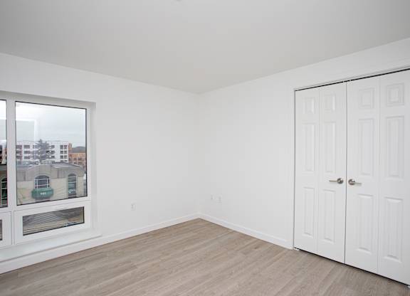 A white room with a large window and a white door.at The Camelot, West Hartford, CT  