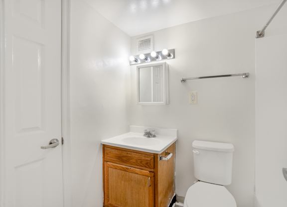 A white toilet sits next to a sink in a small bathroom.