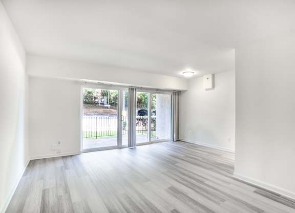 A room with a sliding glass door leading to a balcony.