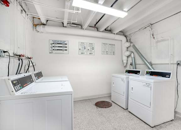A white industrial room with two machines and a sign on the wall.