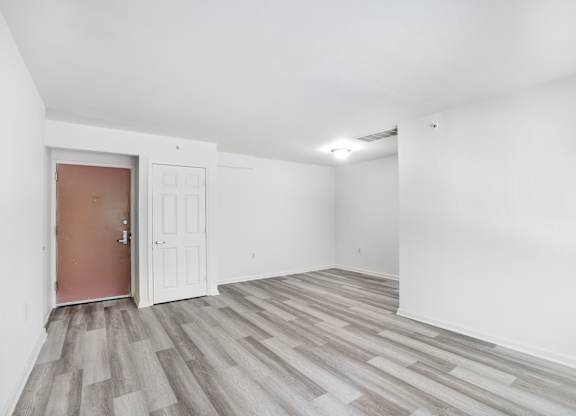 A room with a brown door and white walls.