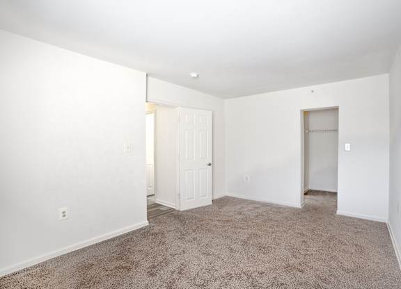 A room with white walls and carpeted floor.