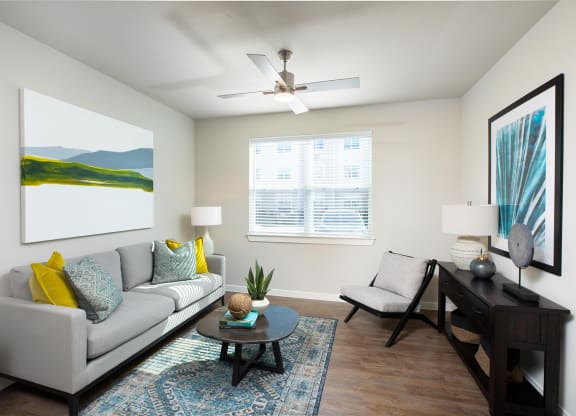 a living room with a couch chair and coffee table at 55 Fifty at Northwest Crossing, Houston, TX 77092