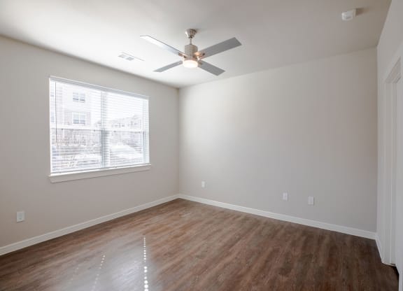 a bedroom with a ceiling fan and a window at 55 Fifty at Northwest Crossing, Texas