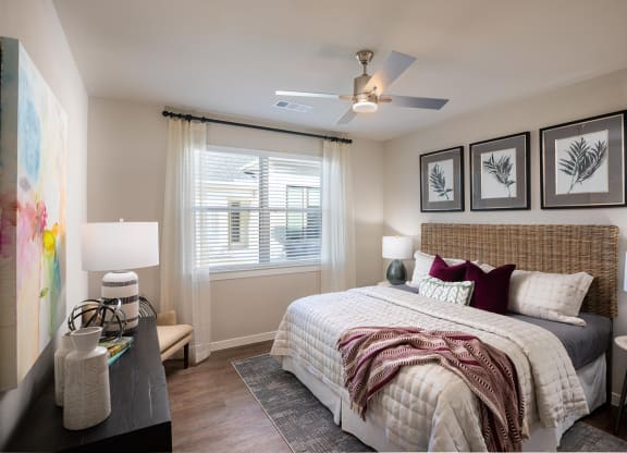 a bedroom with a large bed and a ceiling fan at 55 Fifty at Northwest Crossing, Houston, 77092