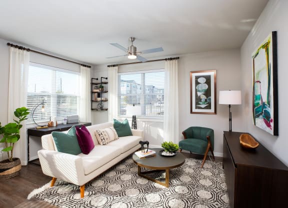 a living room with a white couch and two green chairs at 55 Fifty at Northwest Crossing, Houston, TX 77092