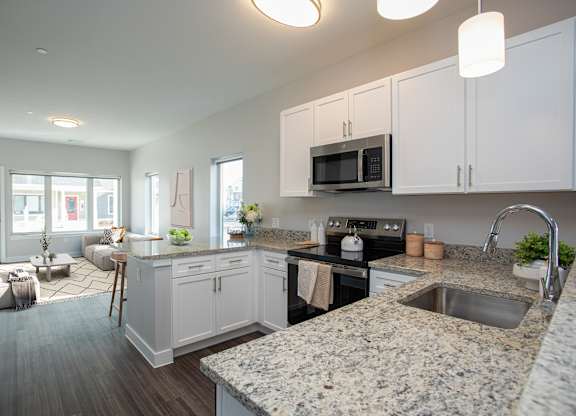 A kitchen with granite countertops and white cabinets at MLK Apartments, Hartford, 06106